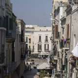 ...permette l�affaccio in piazza Mercantile, tra lenzuola che si muovono al vento, signore affacciate sulla strada, fiori che decorano i balconi
